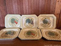 Six octagonal fruit design plates displayed upright and flat
