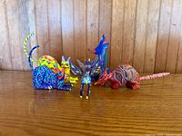 Group of five Oaxaca alebrije animal carvings on wood surface