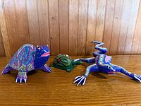 three Oaxaca alebrije figures on wood surface
