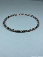Full view of twisted copper and silver-tone bangle