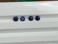 Four round blue sapphires aligned horizontally