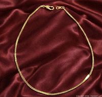 Anklet laid flat on fabric showing full chain and clasp