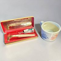 Razor in case alongside Old Spice shaving mug