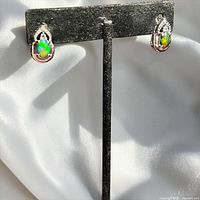 Front view of both sterling silver opal earrings on stand