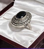 side view of ring in box showing onyx cabochon and marcasite bezel