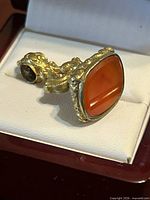 Front view showing carnelian tablet set in bezel and ornate gold-tone housing