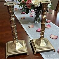 Pair of brass candlesticks on table, showing design details