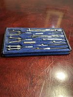 closed velvet-lined case displaying full set of drafting instruments
