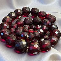Close-up of faceted cherry-amber Bakelite beads showing translucency and cut