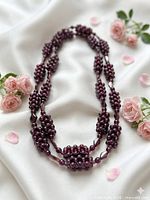 Full view of garnet bead necklace laid out to show cluster pattern