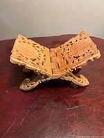 Three-quarter view of carved teak folding book stand closed