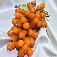 Full view of orange hardstone grape cluster with jade leaves and stone branch