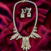 Necklace and earrings on burgundy fabric showing stone clarity and design