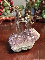 Angled view of glass unicorn on amethyst cluster