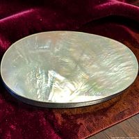 front view showing iridescent mother of pearl surface within silver bezel