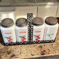 Front view of three shakers in metal caddy