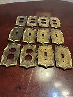 All twelve brass covers arranged to show front texture and patina