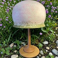 Front view of mushroom statue in garden setting