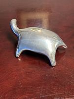 Side view of aluminum turtle sculpture on wood surface