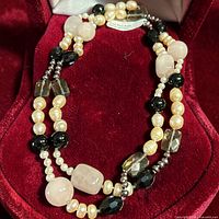Necklace laid in red display box showing bead mix and clasp