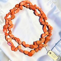 Full view of orange coral nugget necklace coiled