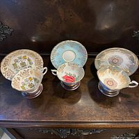 Front view of three teacup and saucer pairs on display
