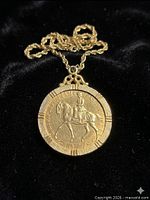 Obverse of coin pendant showing Queen Elizabeth II on horseback