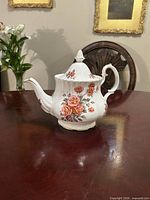 Right side view of teapot showing floral pattern and handle