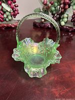 Full view of apple green iridescent glass basket with ruffled rim and handle