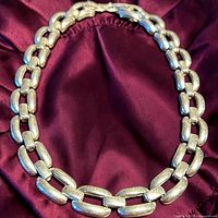 Front view of entire necklace laid flat, showing link style and clasp