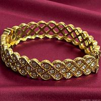 Full view of Nolan Miller gold-tone rhinestone bracelet on fabric