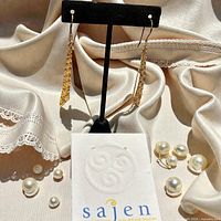 front view of both earrings on stand with Sajen card