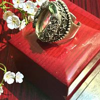 Top view of sterling ring on red box showing sea glass stone and granulated silver detail