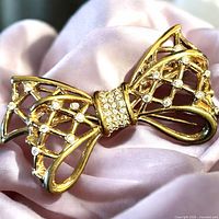 Front view showing gold-tone lattice bow with clear crystals