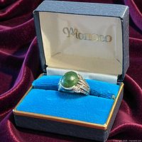 Ring in open presentation box showing jade stone and silver setting