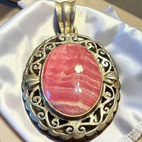 Front view showing rhodochrosite cabochon and openwork silver frame