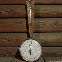 Full view of wall weather station showing wood mount, thermometer, barometer