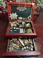 Open jewelry box showing upper tray contents and lower drawer