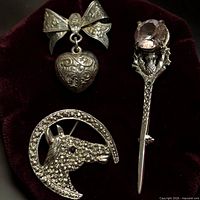 Front view of the three brooches on velvet background