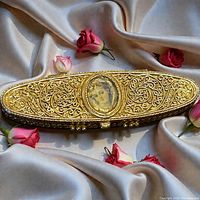 Closed compact showing ornate lid with portrait and surrounding filigree