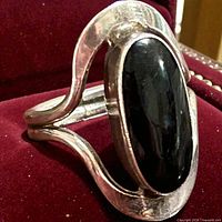 Front view of sterling silver ring showing black onyx stone and sculptural frame