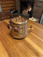 Front view of wooden barrel decanter with brass bands, spigot, lid, ladder and three ceramic mugs