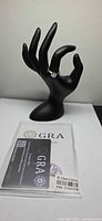 Ring on black hand display with GRA certification card