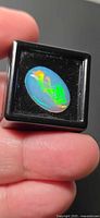 Oval jelly opal in black gem box showing color play
