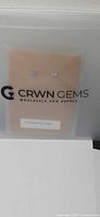 Front view of packaged amethyst stud earrings with CRWN Gems branding
