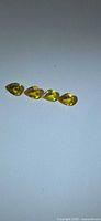Four pear-cut yellow sapphires aligned tip-to-base