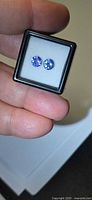 Pair of round violet-blue Tanzanite stones in display case