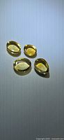 Four golden citrine cabochons on flat surface