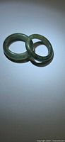 Two green jade rings side by side on light background
