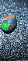 Oval black opal cabochon showing multicolored play-of-color